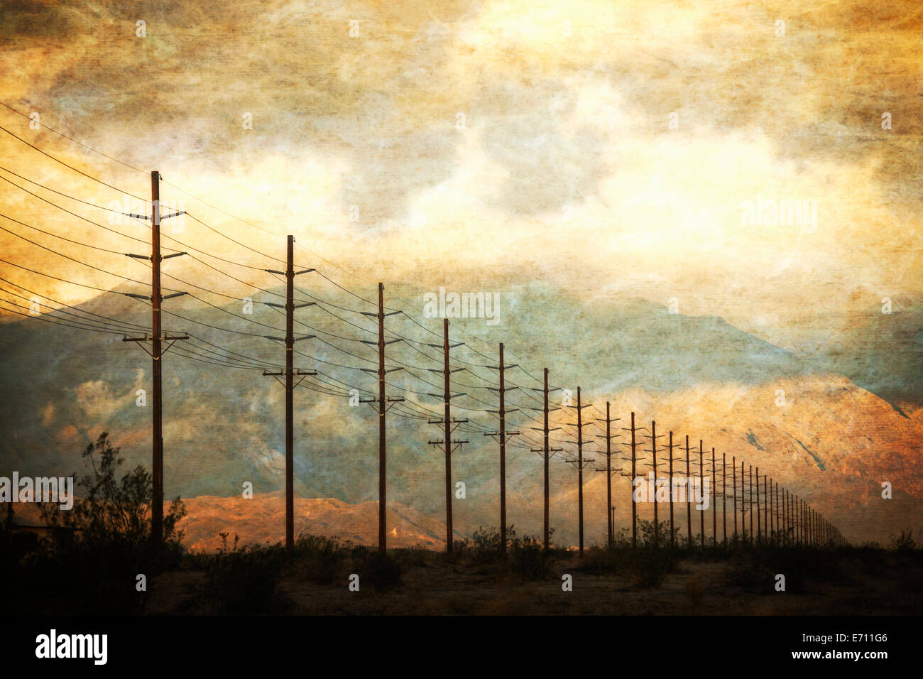 Stromleitungen in Reihen über die Landschaft vor einem Sonnenuntergang Himmel. Stockfoto