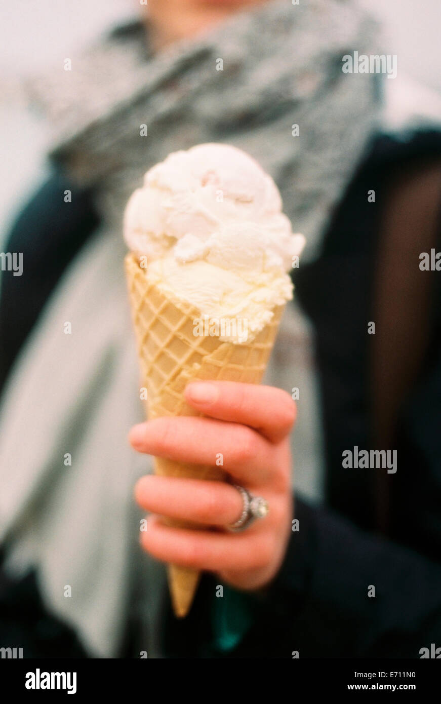 Eine Frau hält sich ein Eis in einem Kegel und lachen. Stockfoto