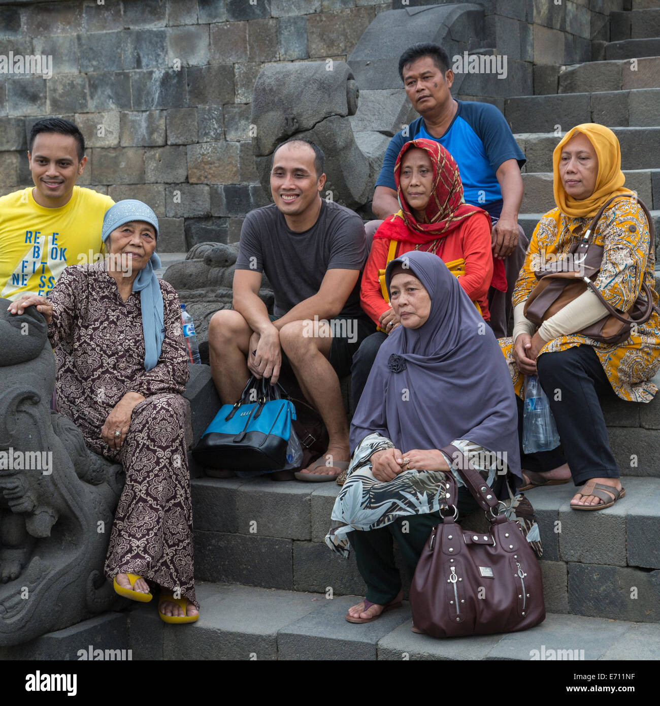 Borobudur, Java, Indonesien.  Javanese Familie posieren für ihr Bild auf der Treppe zu den oberen Ebenen des Tempels. Stockfoto