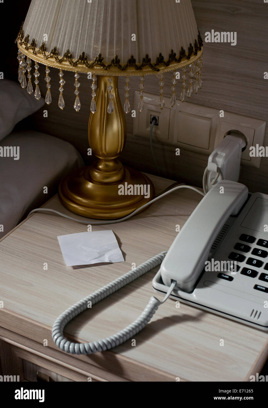 Festnetz-Telefon und leere Notiz auf Hotel Zimmer Nachttisch Stockfoto
