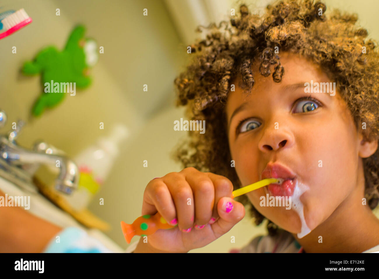 Porträt eines Mädchens Gesicht ziehen, während Zähneputzen Stockfoto