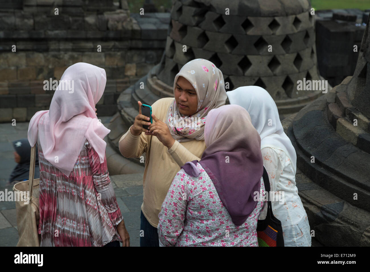 Borobudur, Java, Indonesien.  Junge indonesische Frauen überprüft ein Handy-Foto. Stockfoto