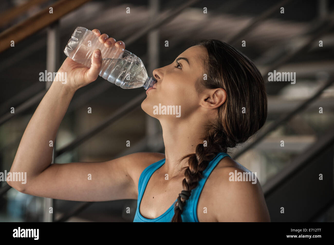 Junge Frau Trinkwasser aus der Flasche Stockfoto