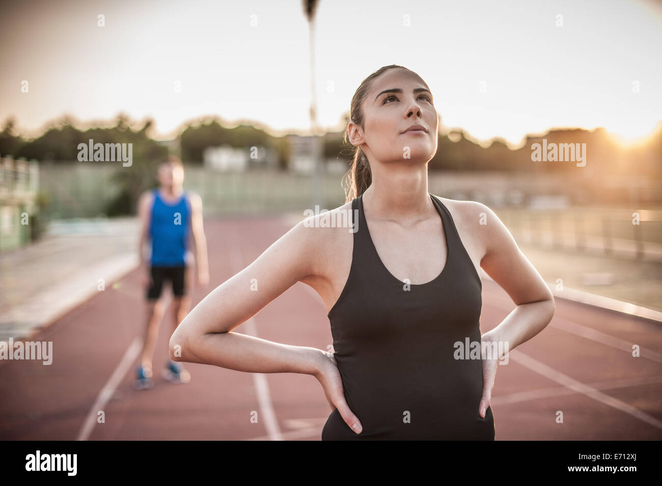 Junge Frau mit Händen auf den Hüften auf Laufband Stockfoto