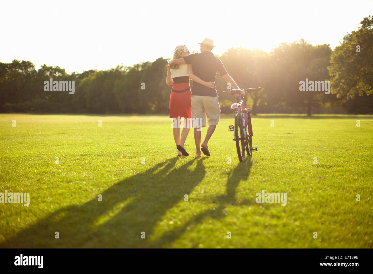 Paar flanieren, während im Park Fahrrad schieben Stockfoto