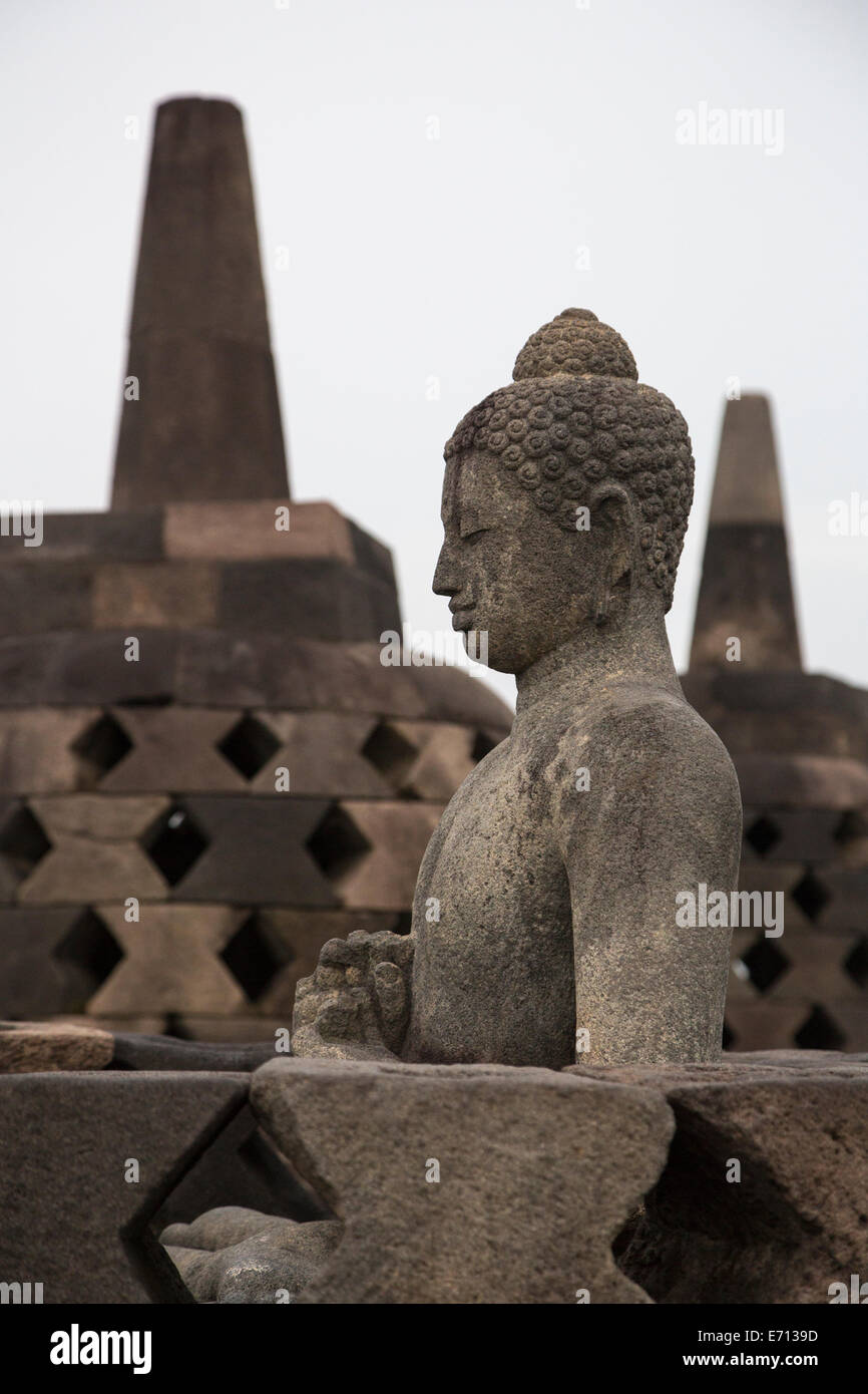 Borobudur, Java, Indonesien.  Buddha-Statue, obere Terrasse.  Die rautenförmigen Löcher symbolisieren verweilende Leidenschaften. Stockfoto