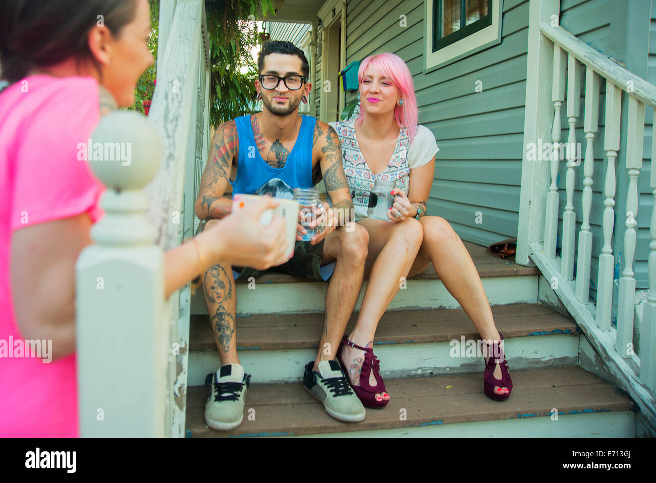 Junge Erwachsene Freunde im Chat vor der Veranda Schritte Stockfoto