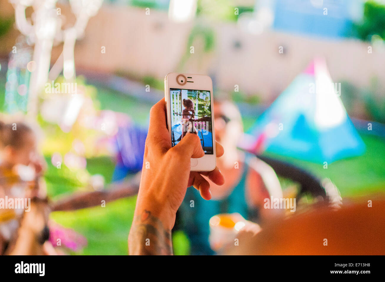 Mitte erwachsener Mann Fotografieren Freunde auf Smartphone im Garten Stockfoto