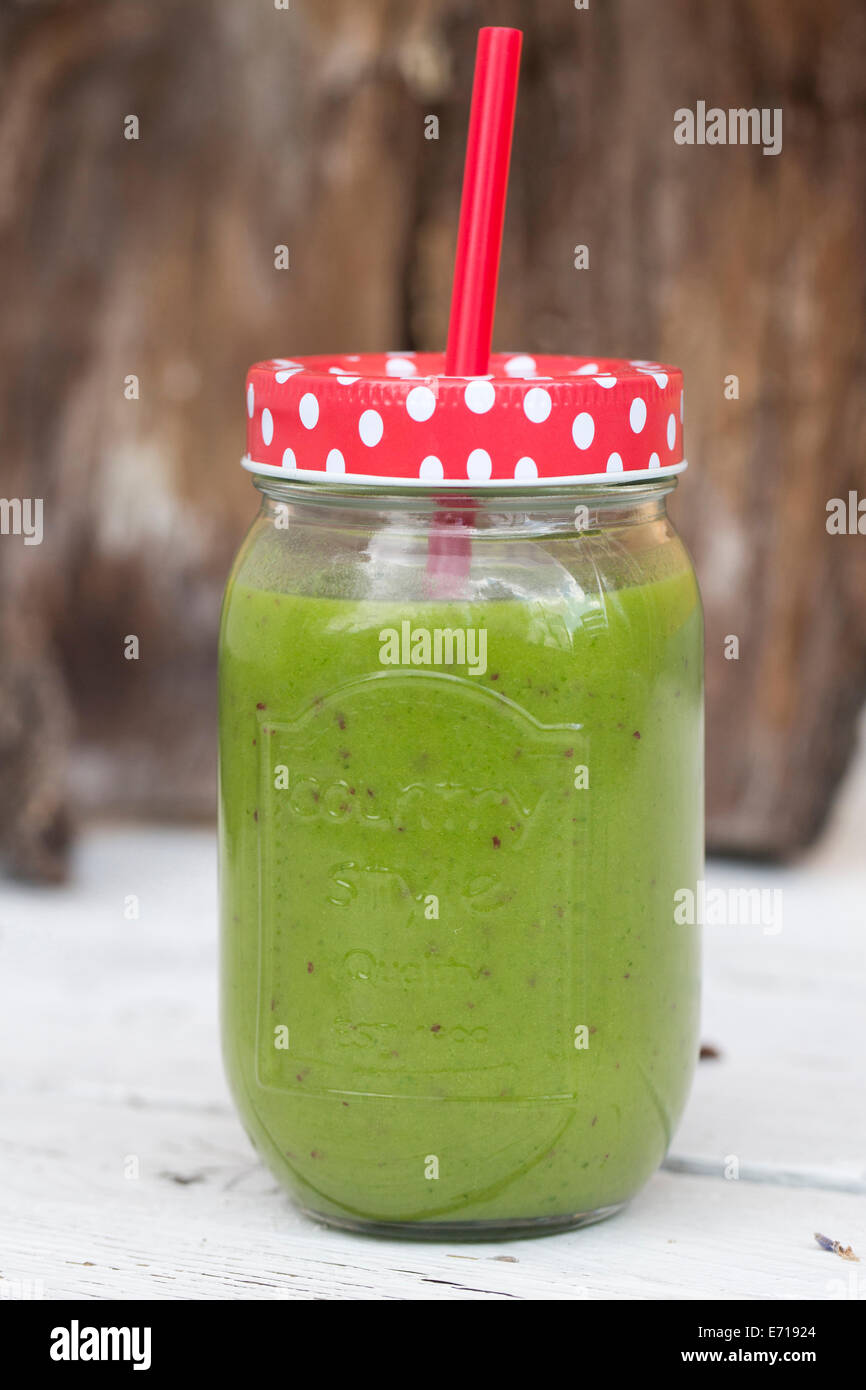 Schraubverschluss Glas mit grünen Smoothie mit Strohhalm trinken Stockfoto