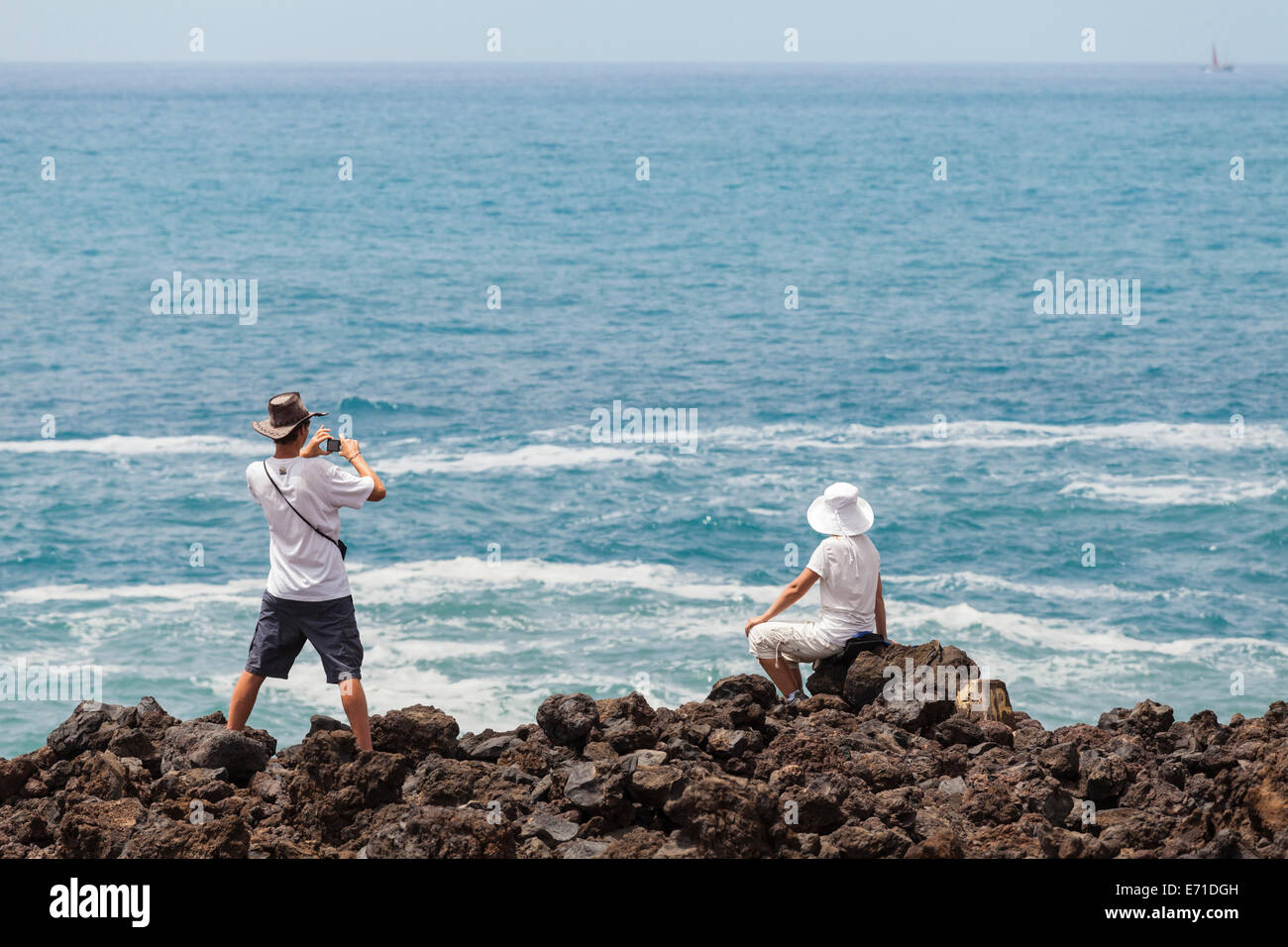 Paar fotografieren auf den Felsen am Ufer in der Nähe von Playa San Juan, Teneriffa, Kanarische Inseln, Spanien Stockfoto