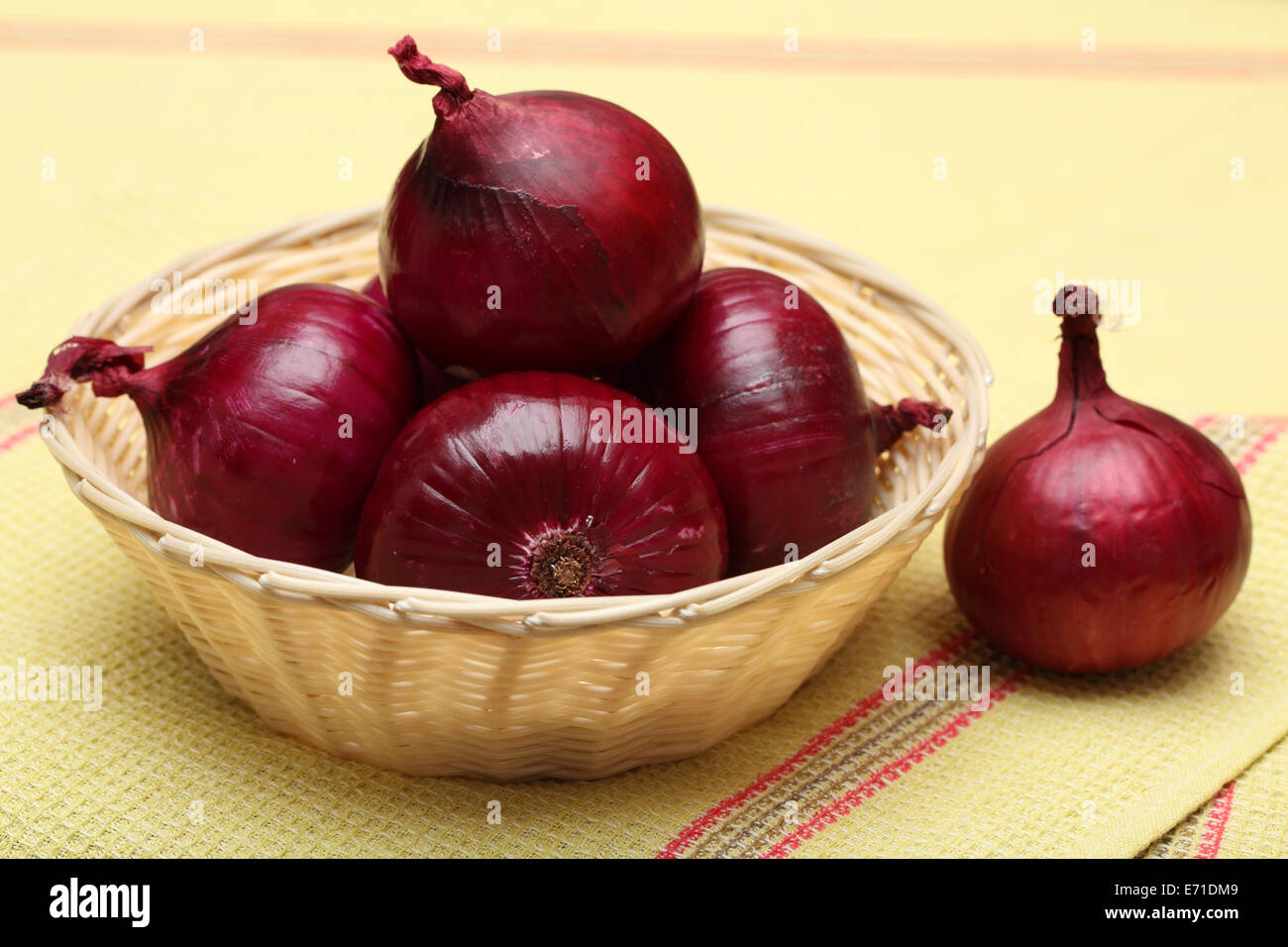 Rote Zwiebeln in den Korb und roten Zwiebeln auf Geschirrtuch. SDOF. Stockfoto