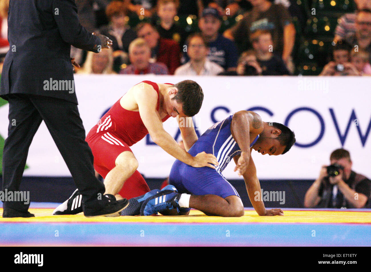 Gareth Jones of Scotland (rot) V Timea Kitiona von Kiribati (blau) in Mens Freestyle 65 kg Ringen an 2014 Commonwealth Games. Stockfoto