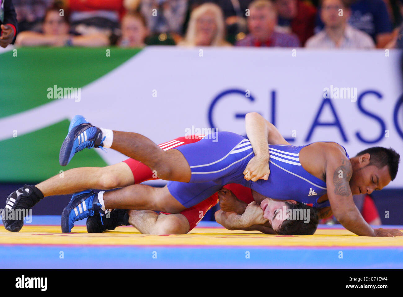 Gareth Jones of Scotland (rot) V Timea Kitiona von Kiribati (blau) in Mens Freestyle 65 kg Ringen an 2014 Commonwealth Games. Stockfoto