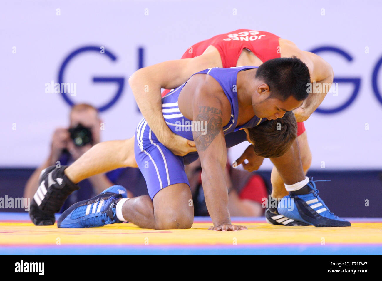 Gareth Jones of Scotland (rot) V Timea Kitiona von Kiribati (blau) in Mens Freestyle 65 kg Ringen an 2014 Commonwealth Games. Stockfoto