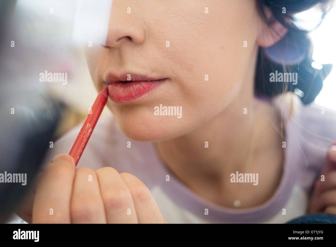 Junge Erwachsene setzen auf Make-up im Spiegel. Stockfoto