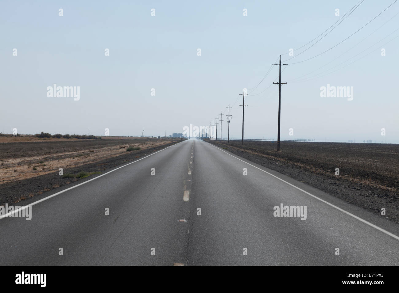 Ländlichen Autobahn verblassen in den Horizont im San Joaquin Valley Farmland - Kalifornien USA Stockfoto