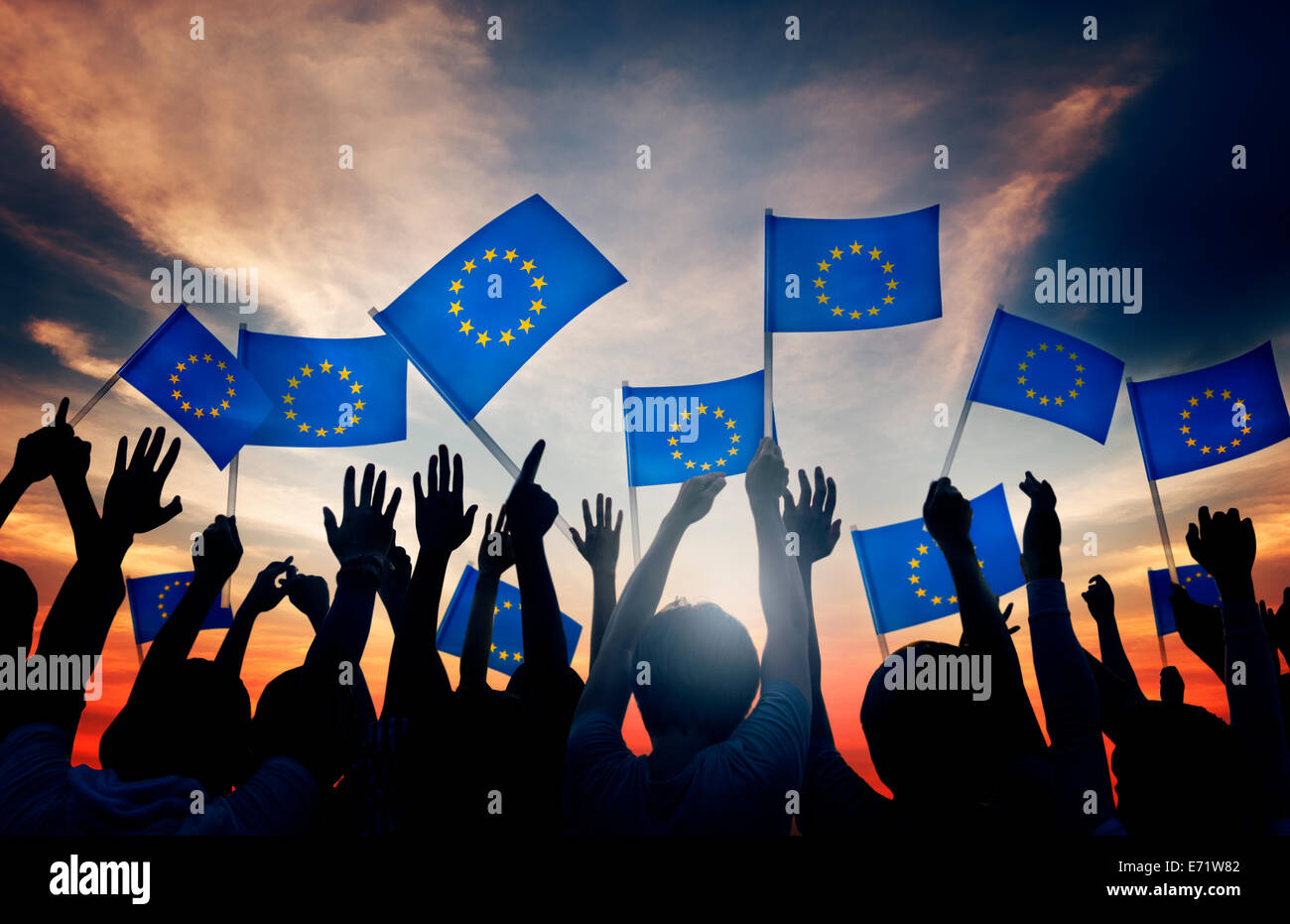 Gruppe von Menschen, die wehende Fahnen der Europäischen Union im Gegenlicht Stockfoto
