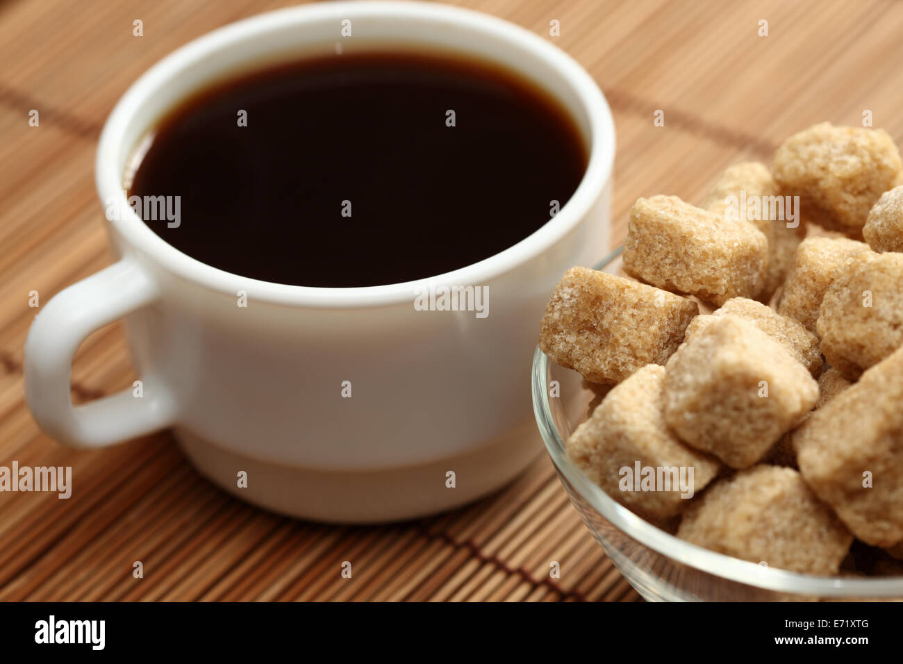 Tasse Kaffee und brauner Rohrzucker in einer Glasschüssel auf Bambus-Serviette. Geringe Schärfentiefe. Selektiven Fokus. Closeup. Stockfoto