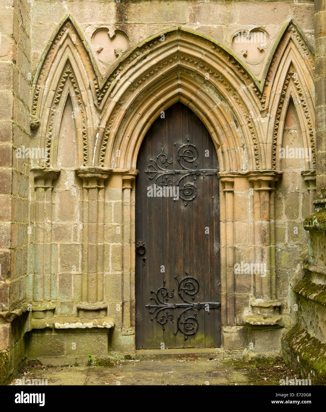 Holztür mit großen & spektakulär dekorative Scharniere umgeben von kunstvollen Steinbögen im historischen Bolton Priory-Kirche in England Stockfoto