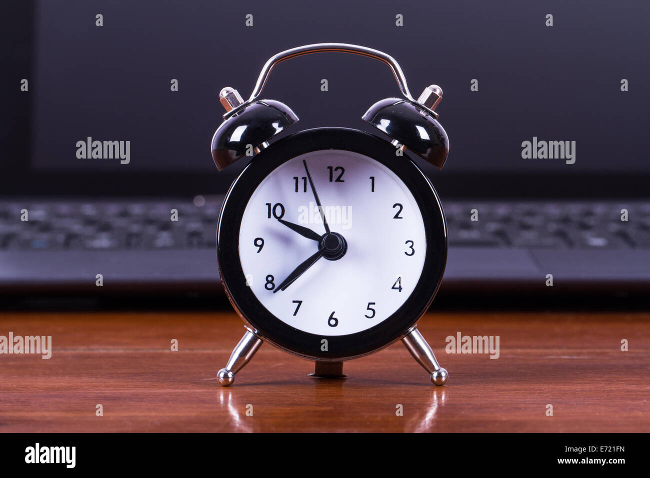 Konzept, Wecker und Laptop auf Holztisch. Stockfoto