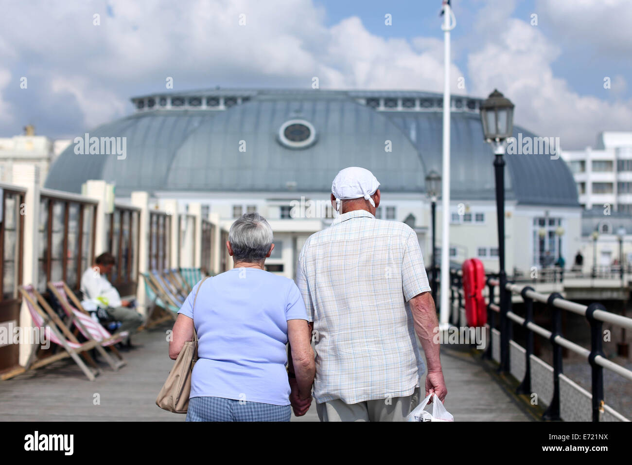 Ein älteres Ehepaar gehen zusammen in der Sonne auf einem Pier, während ein Taschentuch zu tragen Stockfoto