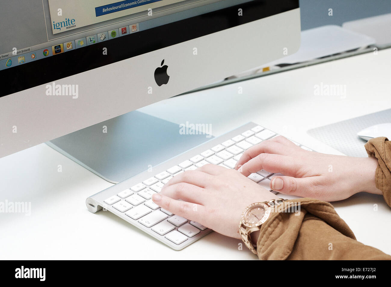 Weibliche Hände Tippen auf der Tastatur eines Apple Imac computer. Stockfoto