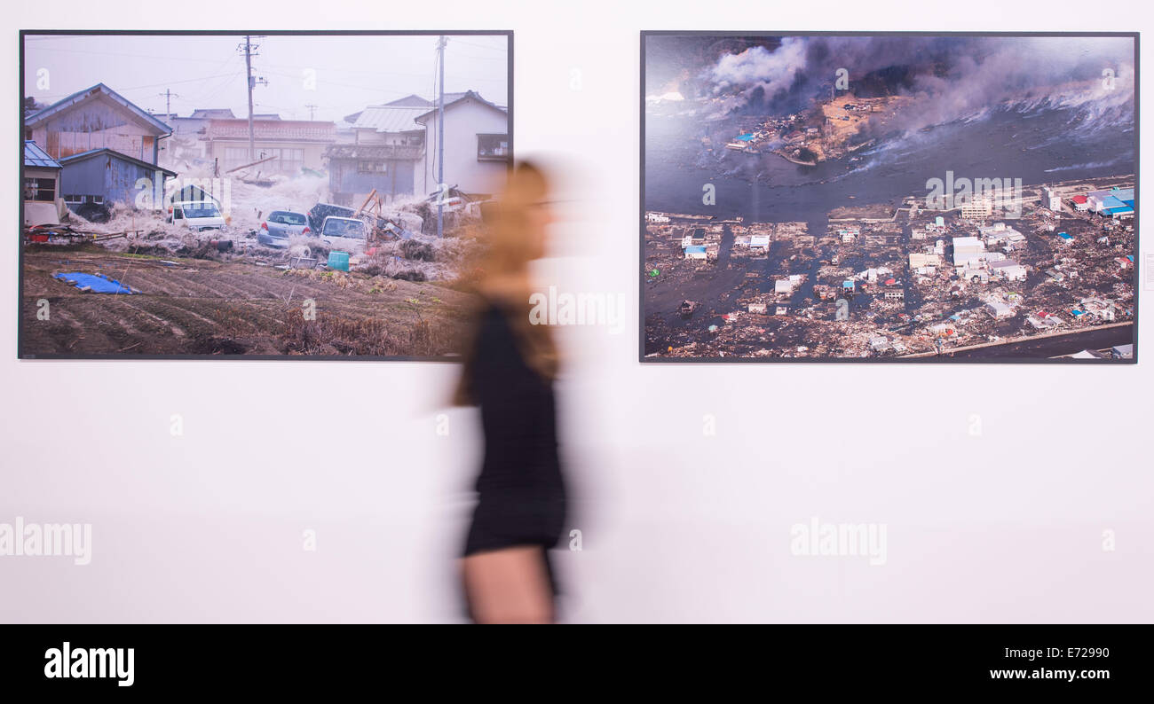 Mannheim, Deutschland. 03rd September 2014. Eine Frau steht vor einem Tsunami Bild vom Fotografen Arita Tsutomu in der Ausstellung "Von Atlantis Bis Heute - Mensch. Natur. Katastrophe "(lit.) "Von Atlantis bis heute - Menschen. Natur. Katastrophe ") in Mannheim, Deutschland, 3. September 2014. Die Ausstellung öffnet am 7. September 2014 und dauert bis März 2015. Foto: Uwe Anspach/Dpa/Alamy Live News Stockfoto