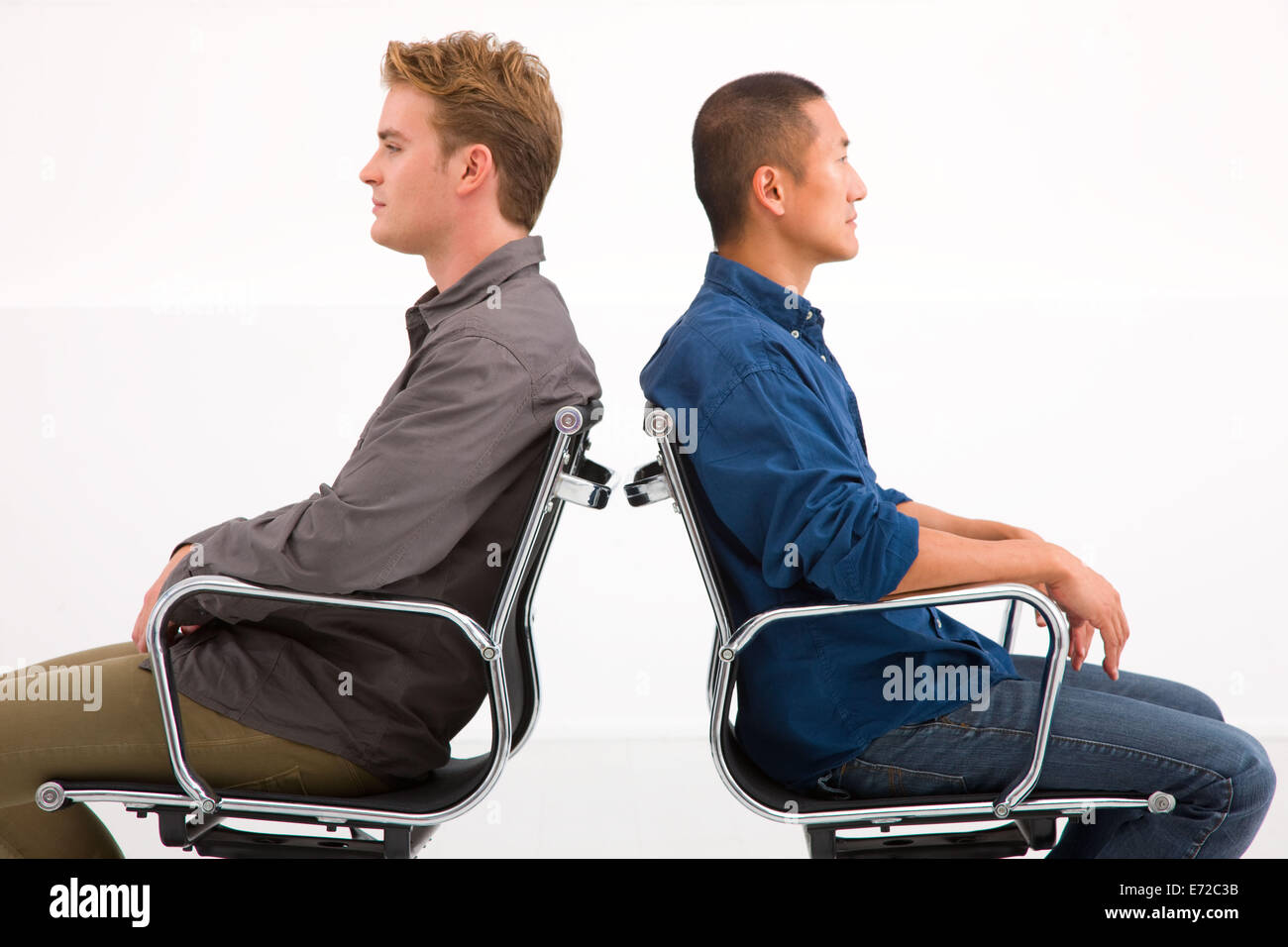 Zwei Unternehmer sitzen auf Stühlen zurück Stockfoto