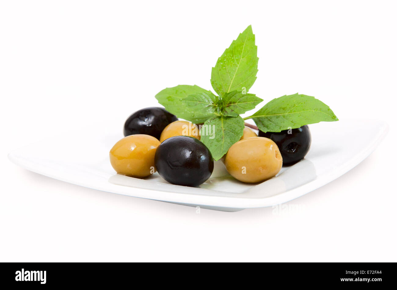 schwarze und grüne Oliven auf weißen Teller Stockfoto