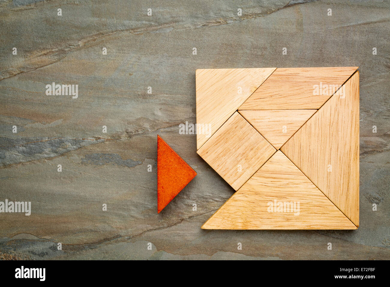 ein fehlendes Stück in einem Quadrat von Tangramsteine, ein traditionelles chinesisches Puzzlespiel, Schiefer Felsen Hintergrund gebaut Stockfoto