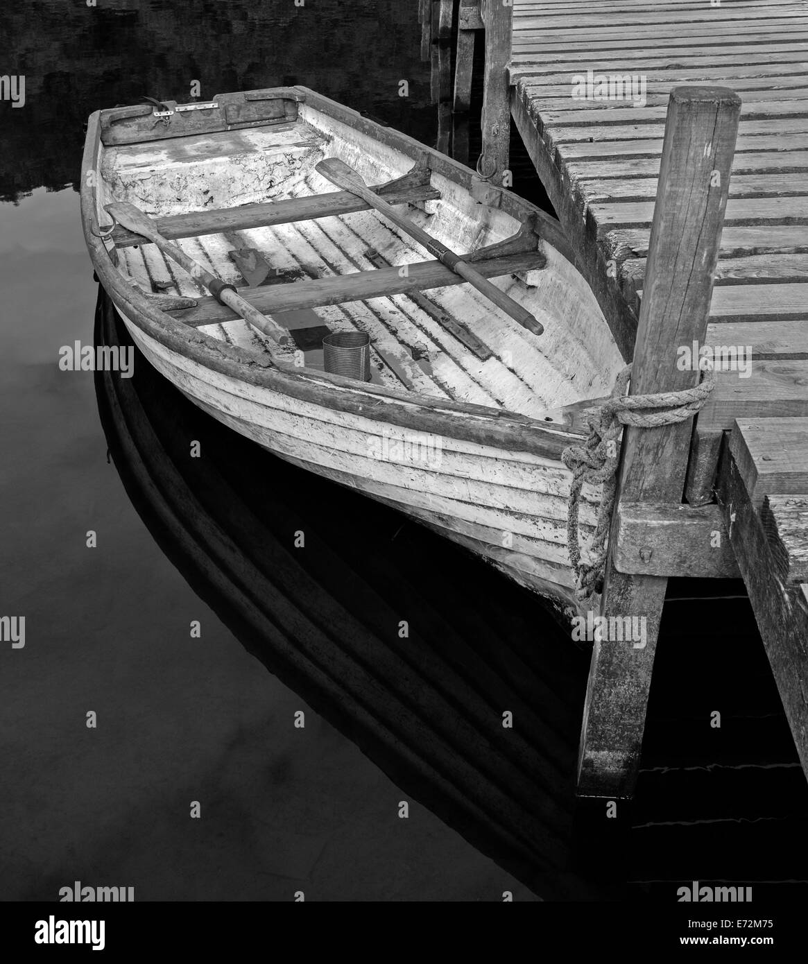 Kleines Ruderboot mit Ruder gebunden an eine Anlegestelle, Loch Lomond, Schottland Stockfoto