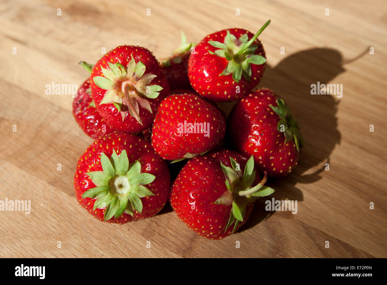 Frische reife rote Erdbeeren obendrauf strukturierte Holztisch Stockfoto