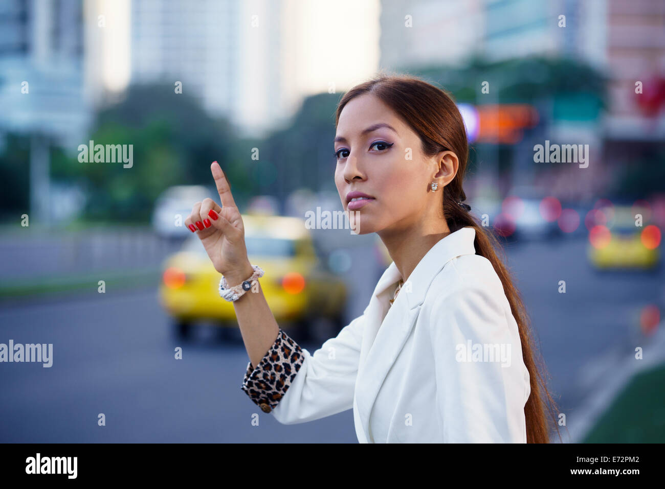 Latin American Business-Frau auf der Straße stehen, gelben Taxi rufen, nach der Arbeit Stockfoto