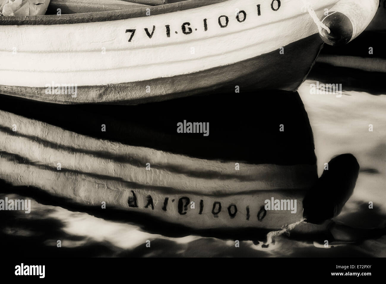 schwarz / weiß Bild von einem kleinen Boot und es ist Spiegelbild im Wasser. Stockfoto