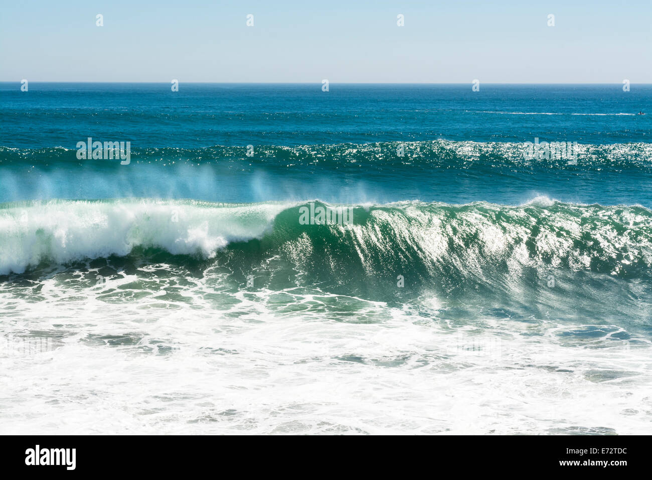 Eine schöne und leistungsstarke türkise Welle bei starkem Wind locken beim weißen Spray Nebel Formen und auf seine Kuppe in Huntington Beach. Stockfoto