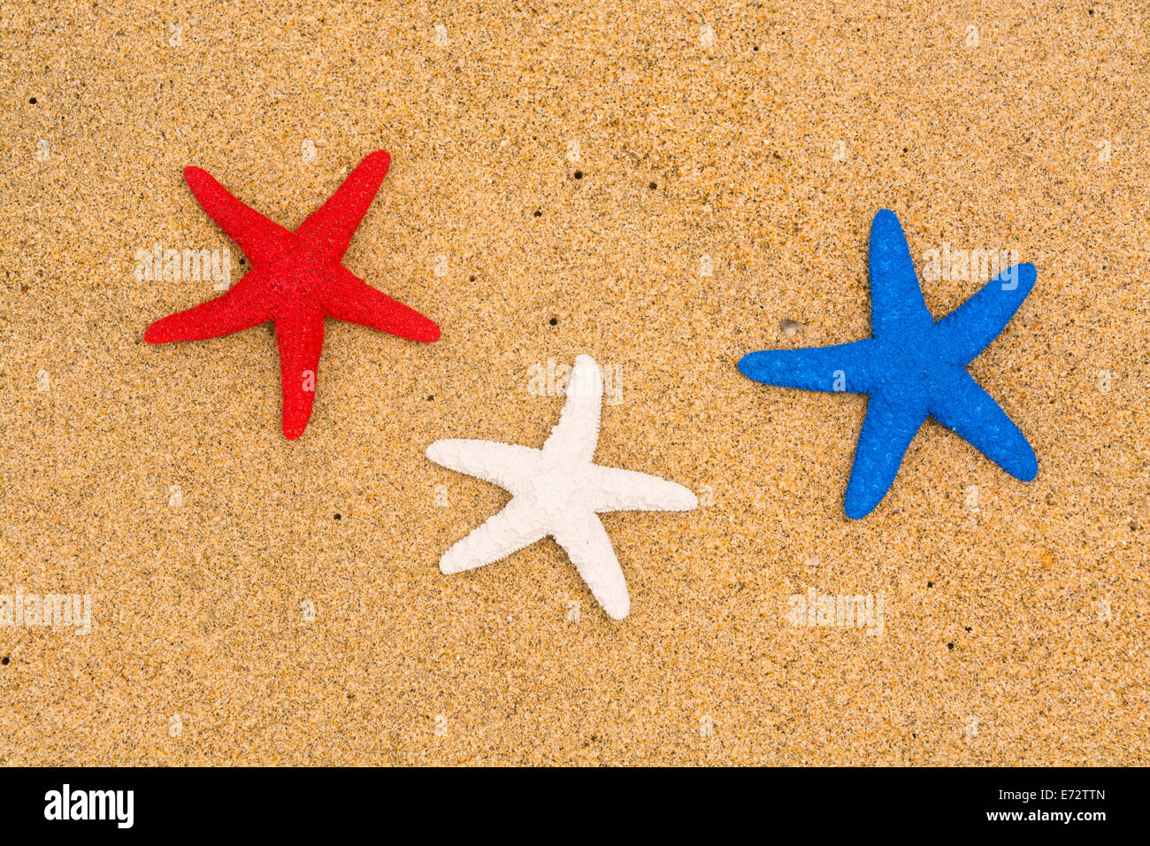 Konzeptionelle Sommer Urlaub Bild der drei roten, weißen und blauen Seestern auf glatten Strand Stockfoto