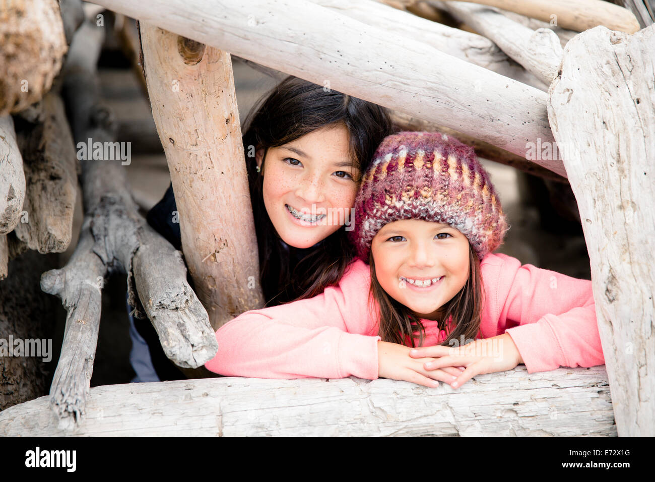 Porträt von glücklichen Schwestern (10-12, 6-7) spielen am Strand Stockfoto