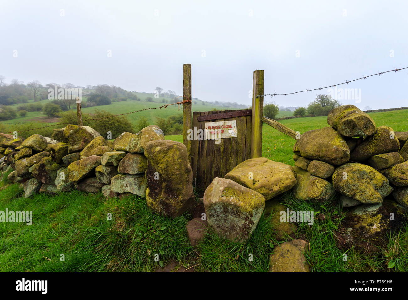 Wanderweg Tor und Trockenmauer in der Nähe von Elton an einem trüben Frühlingstag, Peak District National Park, Derbyshire, England Stockfoto