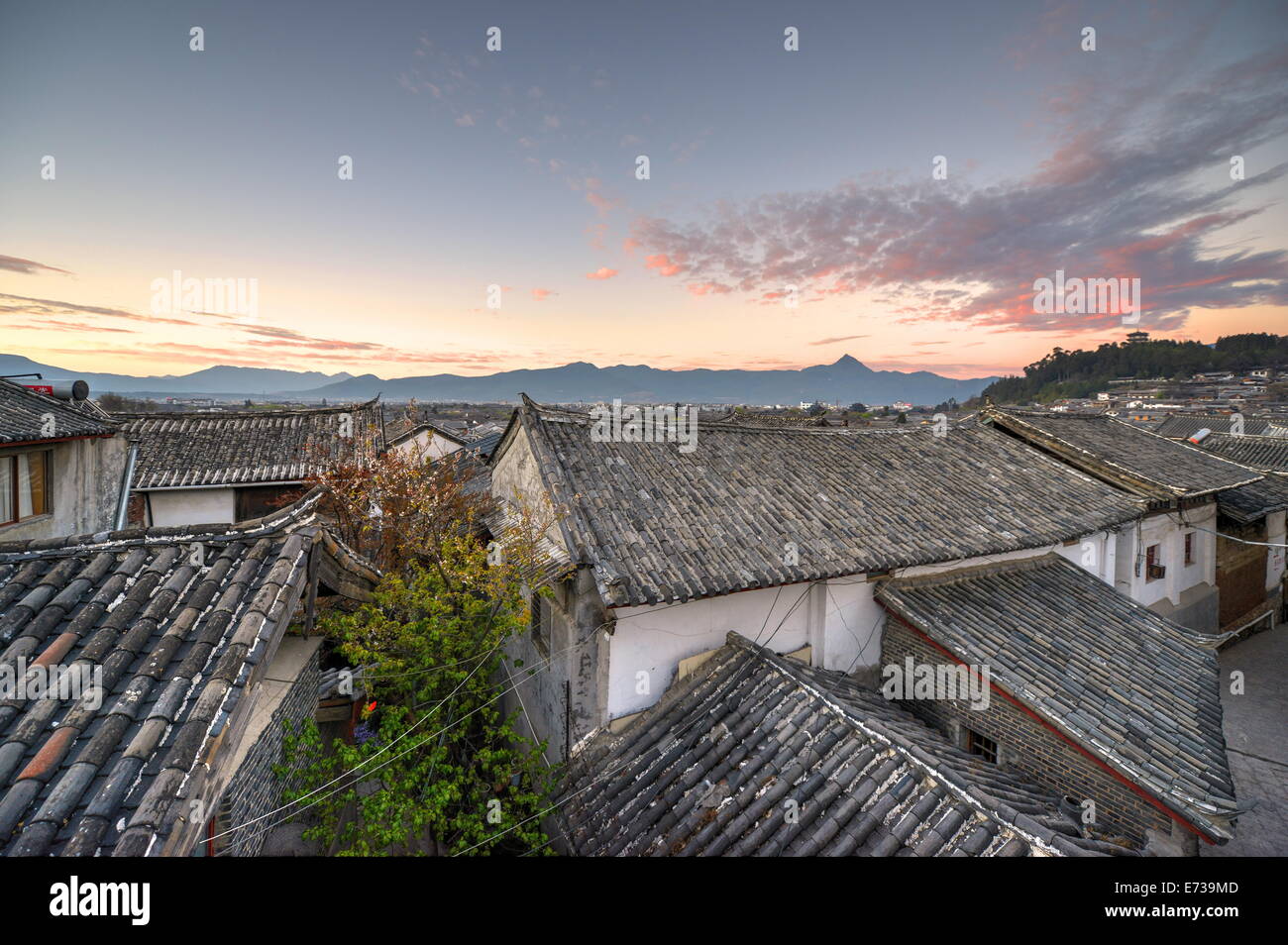 Die Sonne ist sich zu erheben über die Dächer und Berge von Lijiang Altstadt, der UNESCO, Lijiang, Yunnan, China, Asien Stockfoto