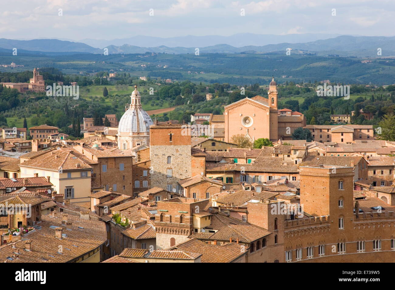 Blick über die Dächer der Stadt, sanften Hügeln, die Basilika San Francesco Prominente, der UNESCO, Siena, Toskana, Italien Stockfoto