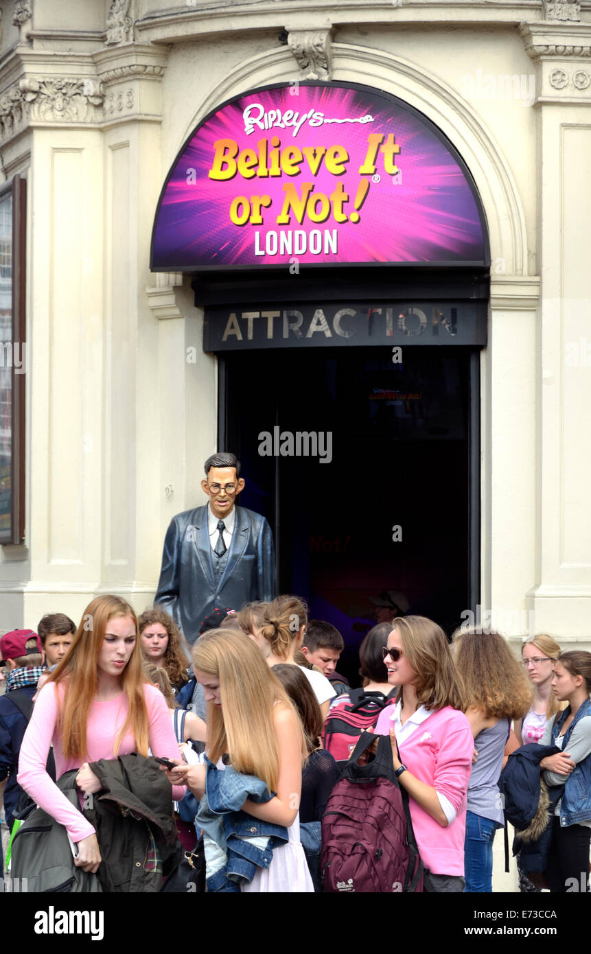 London, England, Vereinigtes Königreich. Touristen am Eingang des "Ripley es glauben oder nicht" am Piccadilly Circus. Statue von Robert Pershing Wa Stockfoto