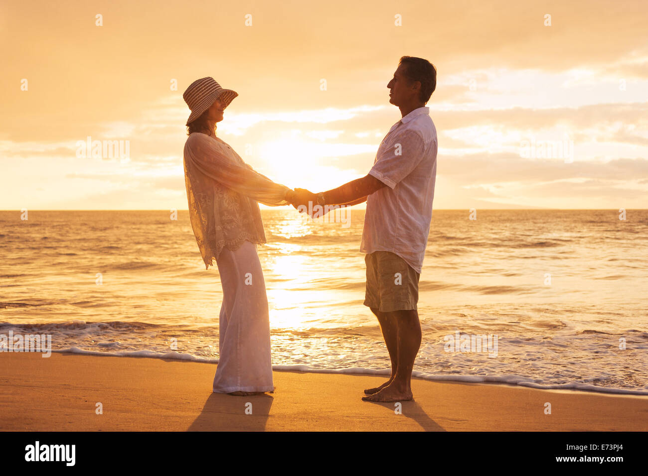 Romantische älteres Paar genießen bei Sonnenuntergang am Strand von Hawaii Stockfoto