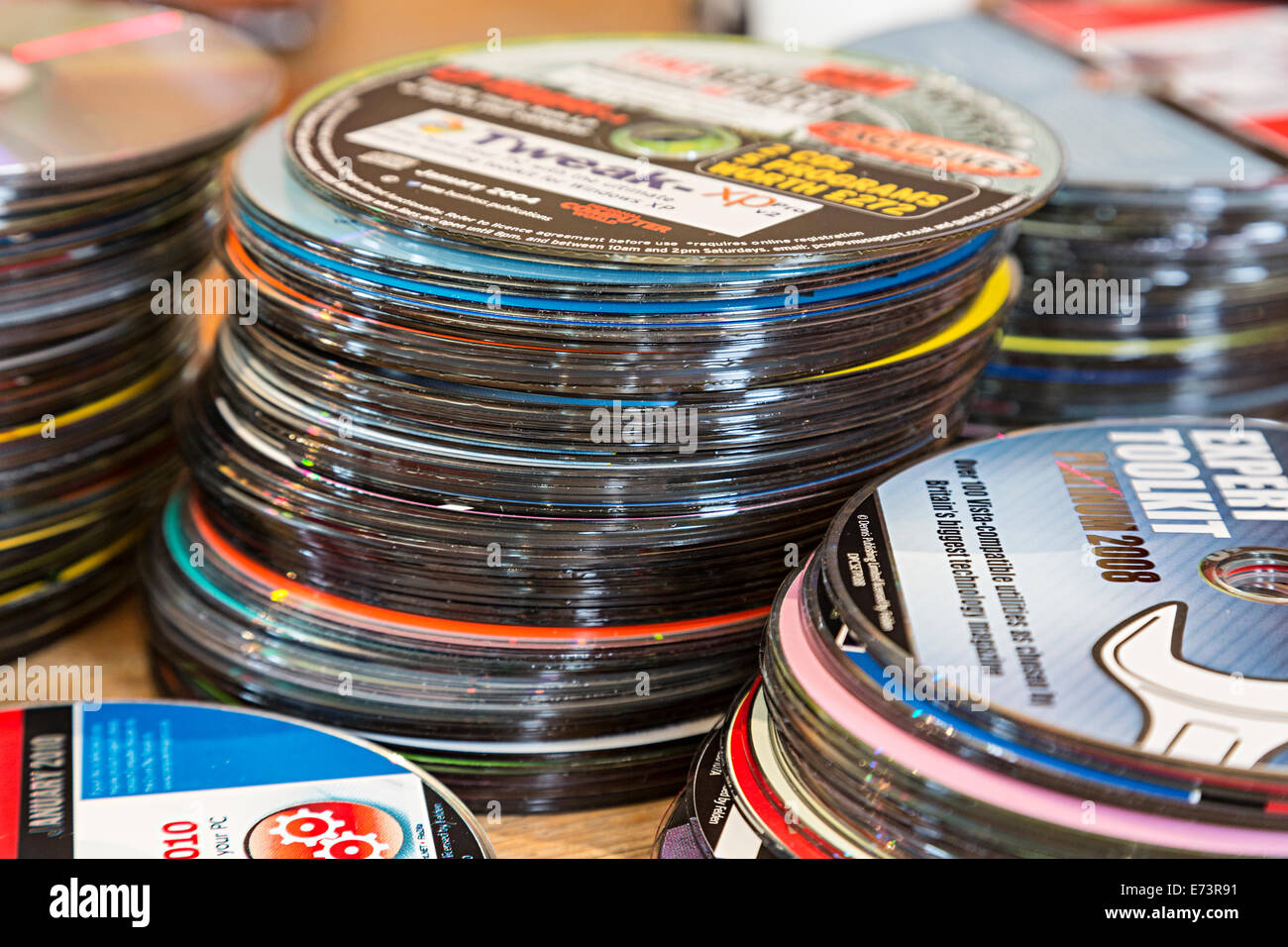 Haufen von alten kostenlose CD-ROM Software Festplatten mit Computer-Zeitschriften für die Entsorgung Stockfoto