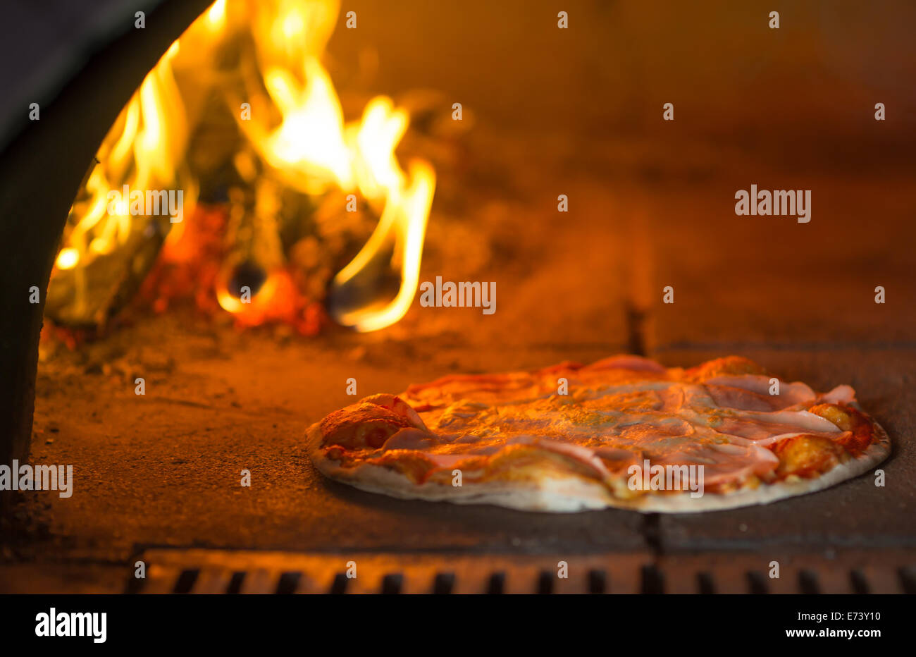Pizza backen im Steinofen Stockfoto