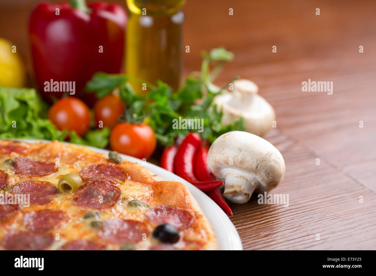 Salami Pizza am Tisch mit Gemüse und leeren Raum Stockfoto