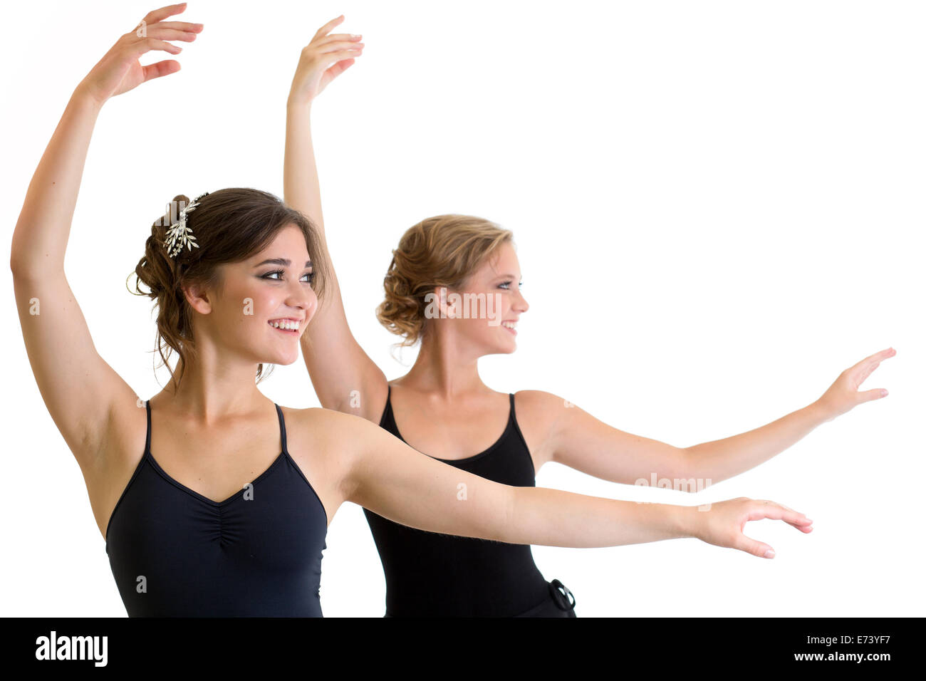 Zwei schöne junge Mädchen machen Sport oder tanzen zusammen isoliert Stockfoto