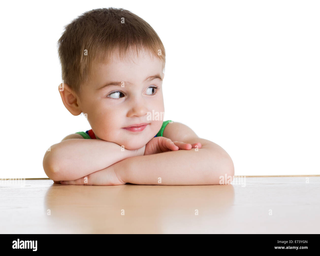 Junge sitzt am Tisch, isoliert Stockfoto