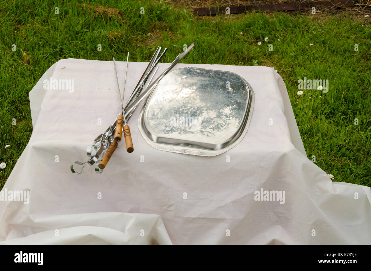 Schaschlik Spiesse und Pad auf kleinen Tisch liegend mit weißen Tischdecke Stockfoto