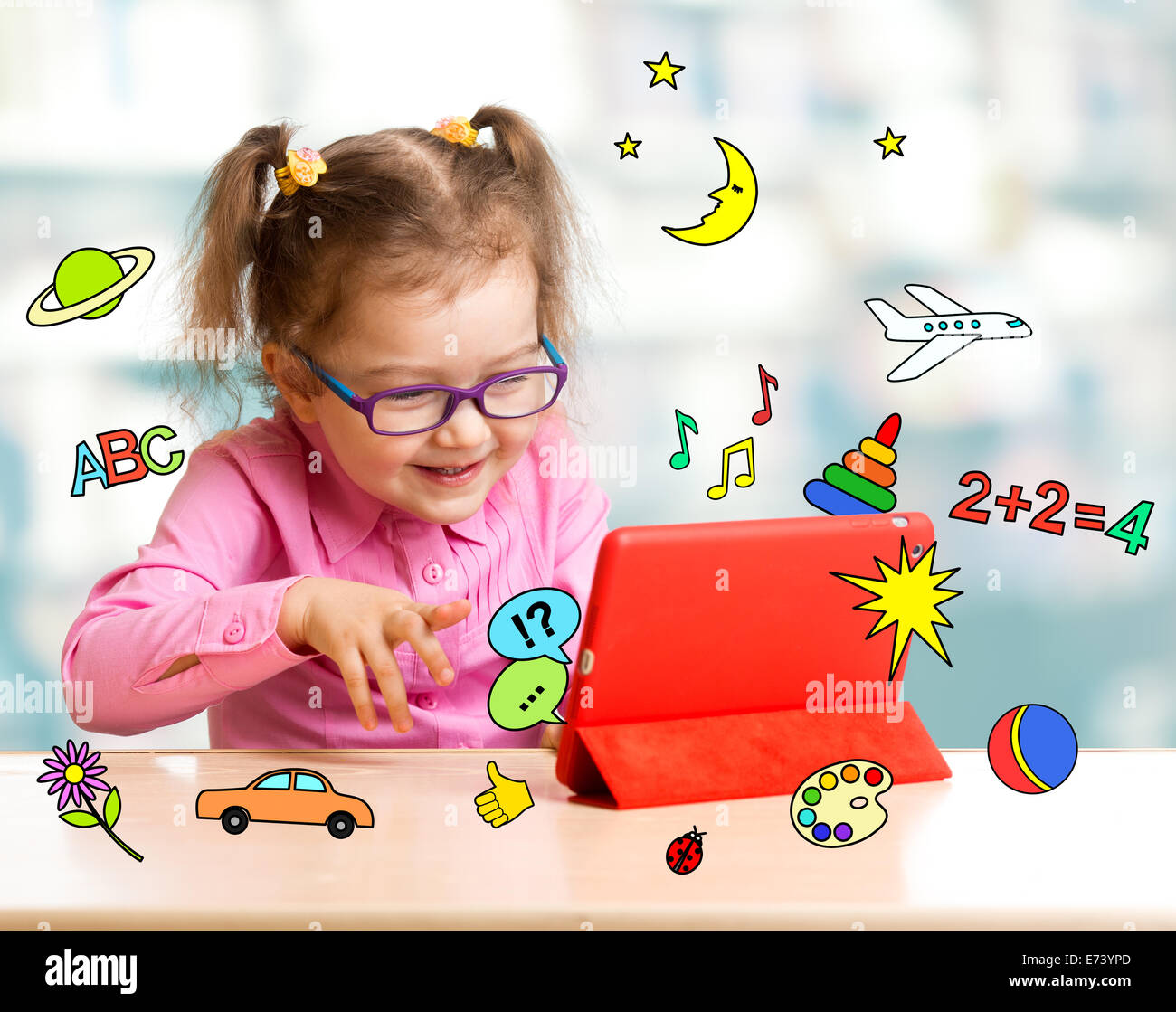 Kind sitzt mit Tablet-Computer und lernen oder spielen mit großem Interesse Stockfoto