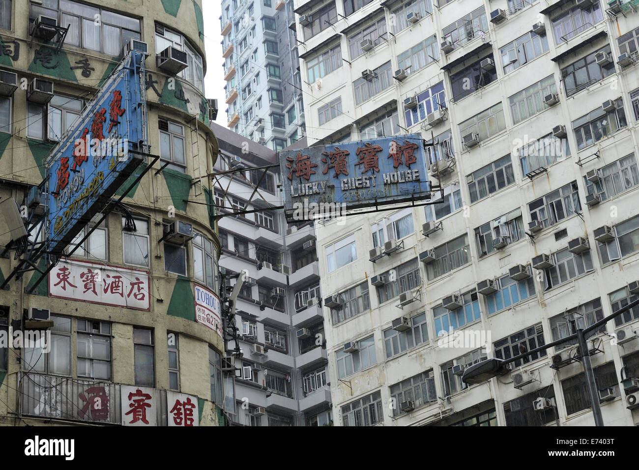 Schilder Werbung Unterkunft zwischen Gebäuden von Apartments und Wohnungen. Kowloon, Hong Kong, China Stockfoto